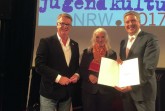 Stolz auf die Auszeichnung: Kultur-Beigeordneter Andreas Kimpel (l.) und Bürgermeister Henning Schulz mit Ministerin Isabel Pfeiffer-Poensgen.