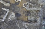 Das Luftbild eines Teils der Grabungsfläche zeigt neben den Mauern von Kellern und Parzellengrenzen auch die dunklen Verfärbungen der hochmittelalterlichen Gruben und Pfostenlöcher. © Eggenstein/Exca, R. Gündchen