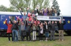 Begeistert für die Demokratie - Die Organisatoren der U18-Europawahl freuen 
sich gemeinsam mit Gästen und „Jungwählern“ vor dem als Europaflagge 
lackierten Jugendwaggon an der Bahnmeisterei in Farmbeck, Foto: Ilja Nowodworski