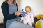 Mit Puppe und Laptop: PEKiP Kursleiterin Dagmar Lamprecht bei Ihrem Online-Kurs „PEKiP Digital“. Foto:
