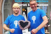 Tobias Schmidt (links) und Karl Heinz Schäfer von der Tourist Information Paderborn präsentieren die diesjährigen Libori-Artikel. Foto: © Stadt Paderborn