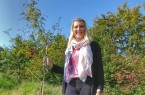 Gut gewachsen: Laura Schuster vom KlimaPakt Lippe mit der Vogelbeere, die der Kreis vergangenes Jahr beim Einheitsbuddeln gepflanzt hat. Foto: Kreis Lippe