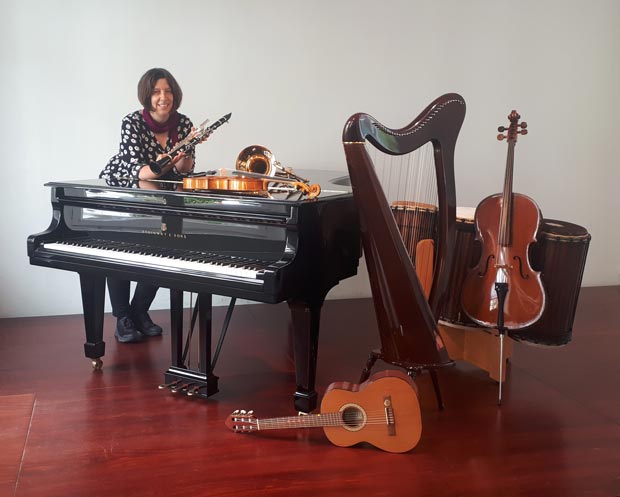 Schulleiterin Susanne Greschok mit einer Auswahl an Instrumenten. Foto: © Johannes-Brahms-Musikschule