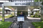 Bertelsmann Personalvorstand Immanuel Hermreck mit dem Spendenscheck an die SOS-Kinderdörfer. (© Bertelsmann)