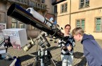 Das Foto zeigt links Bente Kähler, Leitung der Volkssternwarte Ubbedissen, und Julius, der einen Blick auf die Sonne wirft. Foto: © Weserrenaissance-Museum Schloss Brake